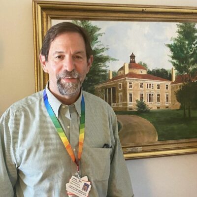 A man standing in front of a painting.
