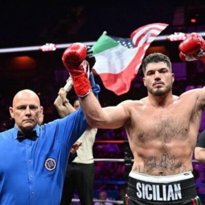 A boxer is celebrating after winning a boxing match.