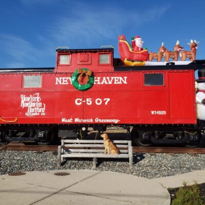 A red caboose with santa claus on it.