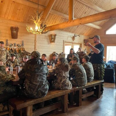 Hunter education class in a log cabin.