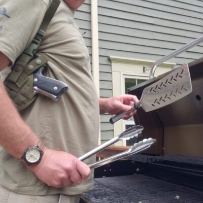 Man grilling with concealed firearm.