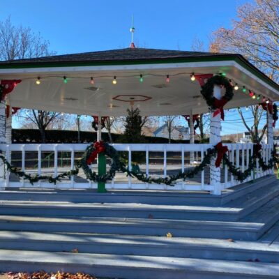 A gazebo in a park with christmas decorations.