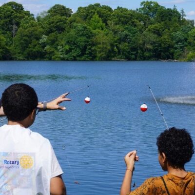 A group of children are fishing in a pond.