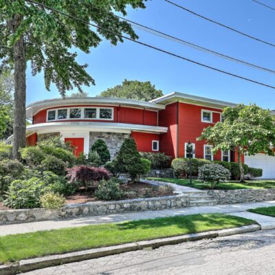 Red house with landscaped yard.
