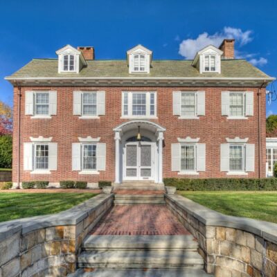 A brick house with steps leading to the front door.