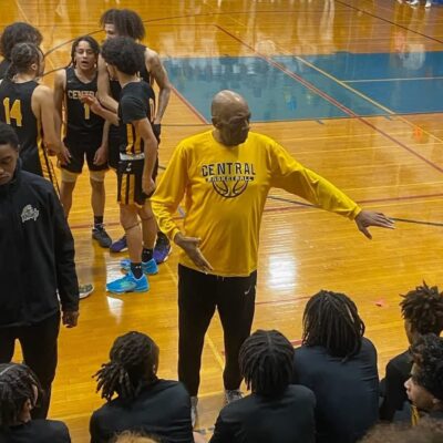 Coach giving instructions to a basketball team during a timeout.