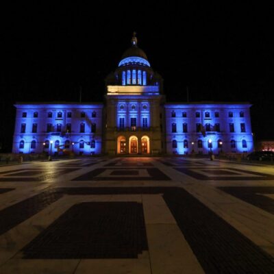 A large building illuminated in blue at night, commemorating World Diabetes Day.