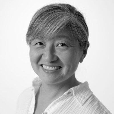 A black and white photo of a woman smiling.