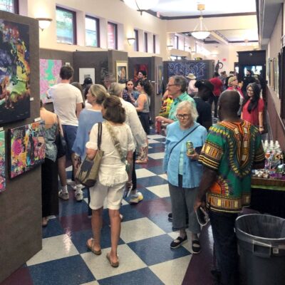 A group of people looking at art in a hallway.