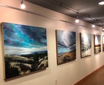 A hallway adorned with exquisite art pieces and paintings hanging proudly on the wall.