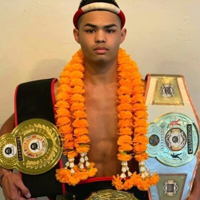 Young Muay Thai champion with belts.