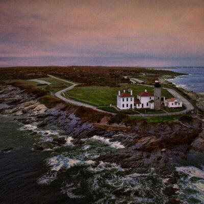 A large house on the edge of an ocean.