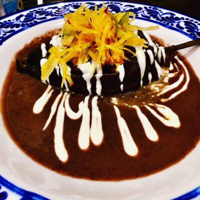 A white and blue plate topped with chocolate and whipped cream.