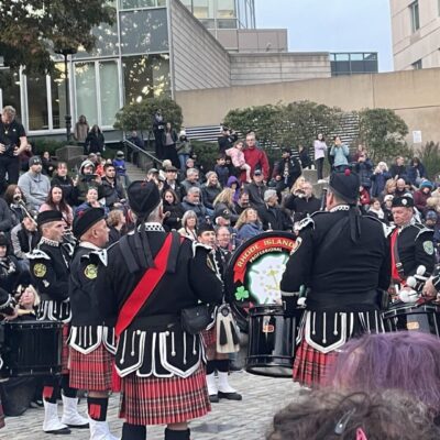 A group of people in kilts are playing in front of a crowd during the Waterfire Salute to Veterans event.