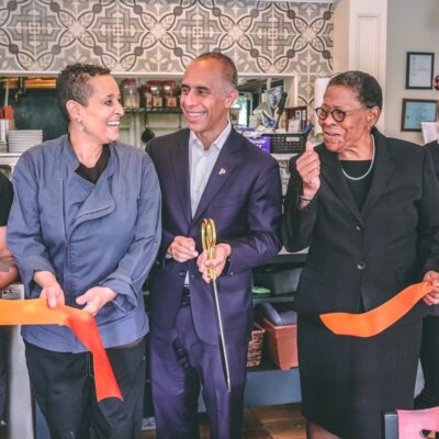 A group of people cutting a ribbon at a restaurant.
