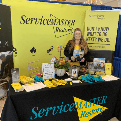 A woman at a servicemaster booth at a trade show.