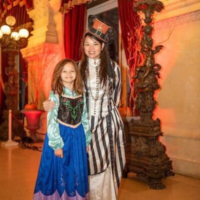 A woman and a little girl dressed up in Halloween costumes.