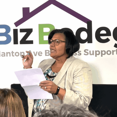 A woman holding a piece of paper in front of a group of people.