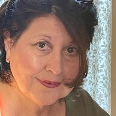 Woman with dark hair and sunglasses.