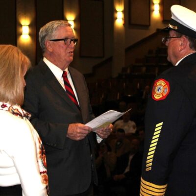 A man in a suit and the Cranston Fire Chief in a dress.
