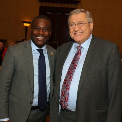 Two men in suits standing next to each other at the Davinci Center.