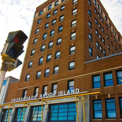 A crossroads with a large building and a traffic light in front of it.
