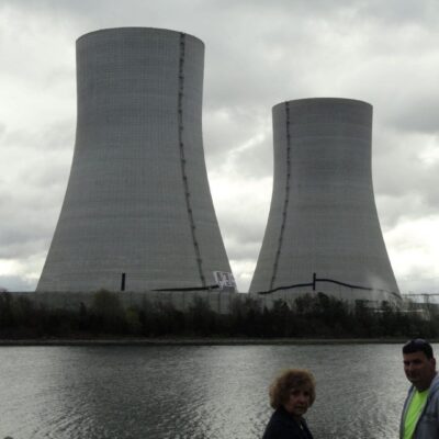 Two people standing next to a body of water.