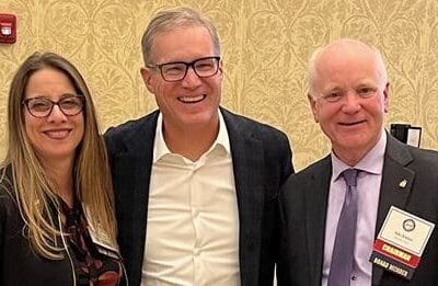 Three business people posing for a photo in a conference room.