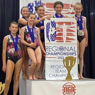 A group of gymnasts posing for a picture on a podium.