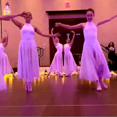 Ballet dancers in lavender dresses performing.