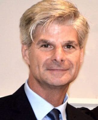 A man in a suit and tie is posing for a photo.