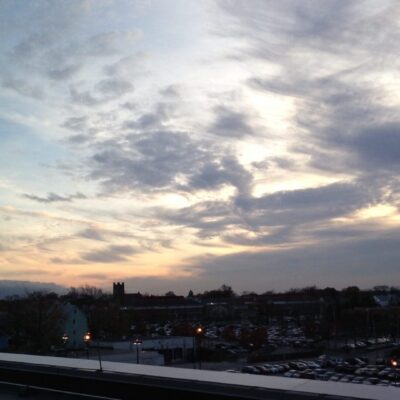 A cloudy sky over a parking lot, with homeless individuals in Rhode Island.