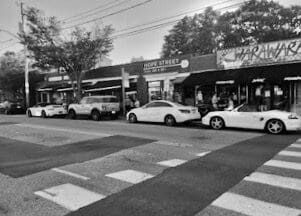A black and white photo of cars parked on a street.
