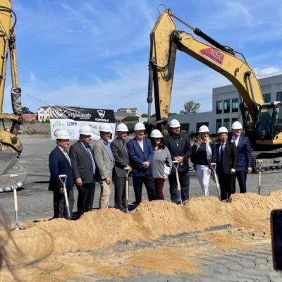 A group of people standing in front of a construction site.