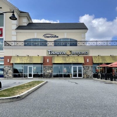 A restaurant with a parking lot in front of it.
