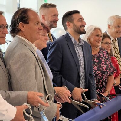 Group cutting ribbon at grand opening.