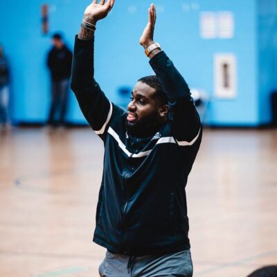 A Johnston sports basketball coach raising his arms in the air.