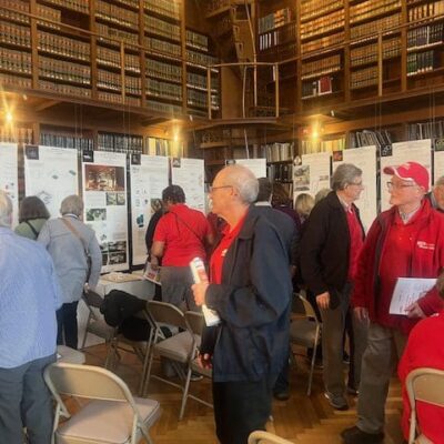 A group of people looking at posters in a library ADU.