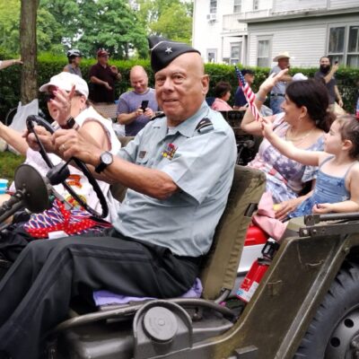 A veteran driving a jeep in a parade.