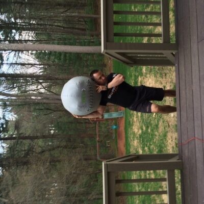 A man carrying a large bag on a deck.