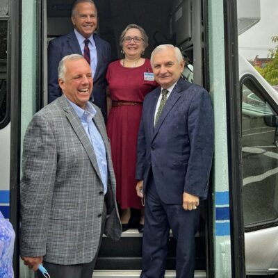 A group of people standing in front of a bus.