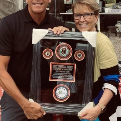 A man and woman holding a framed award.