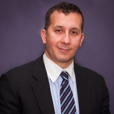 A man in a suit and tie posing for a National Restaurant Association photo.