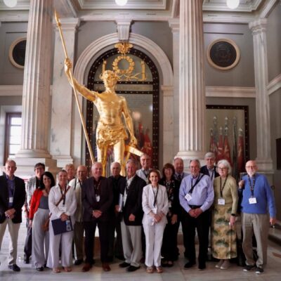 A group of people standing in front of a statue.