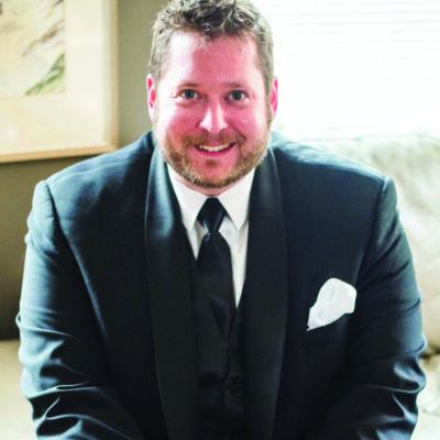 A man in a suit sitting on a couch.