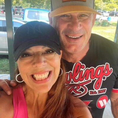 A man and woman posing for a selfie in a park.