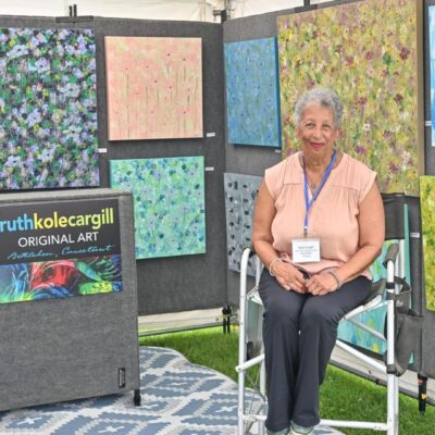 A woman sitting in front of several fabric samples.