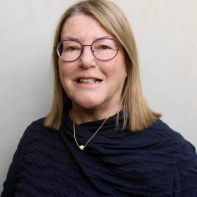 A woman wearing glasses and a necklace.