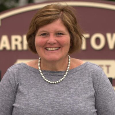A woman smiling in front of a sign that says carrington towers.