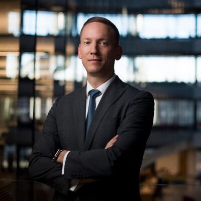 A man in a suit and tie standing in an office.